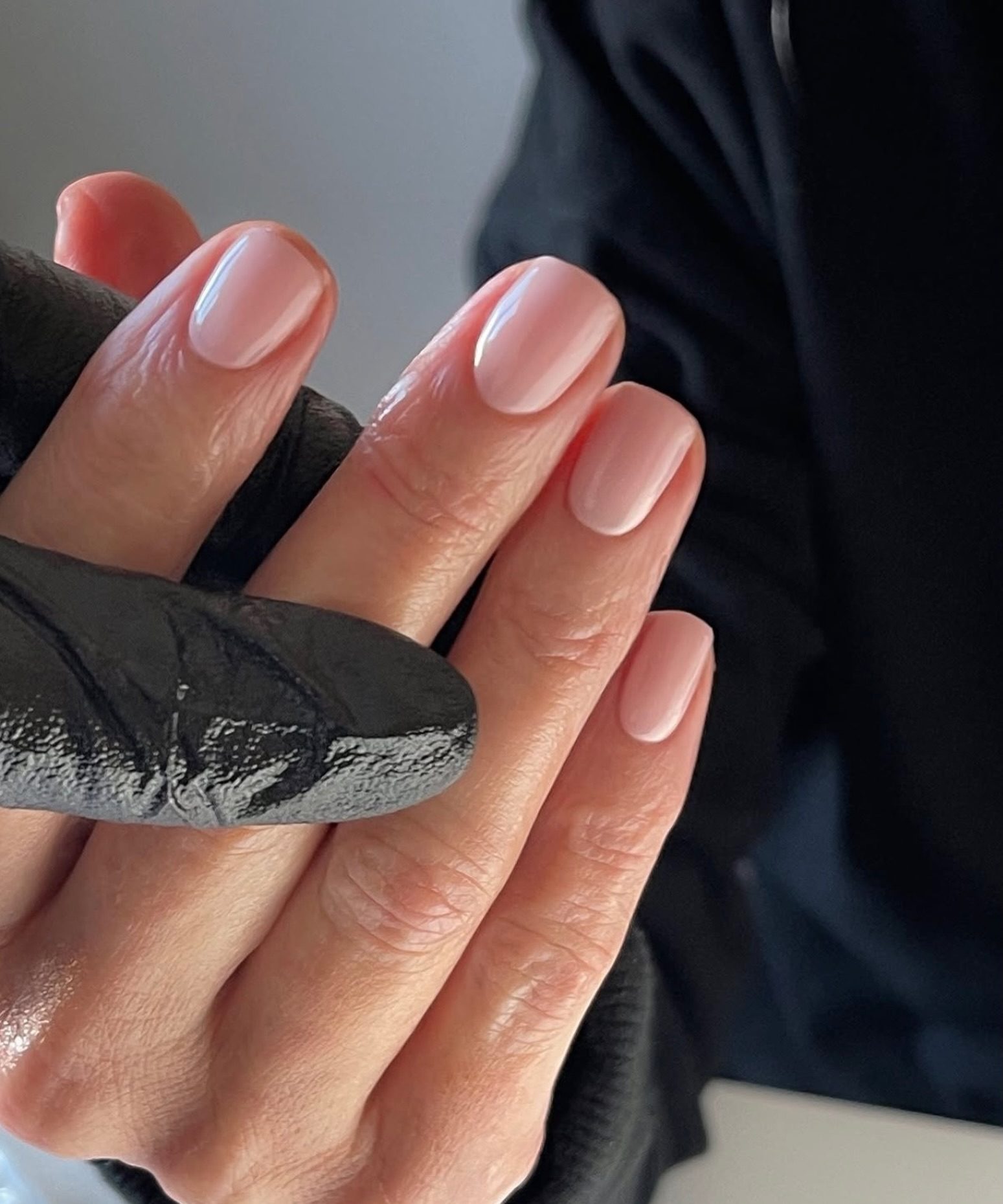 Close view of a finished nude gel manicure, the cuticle line clean and even